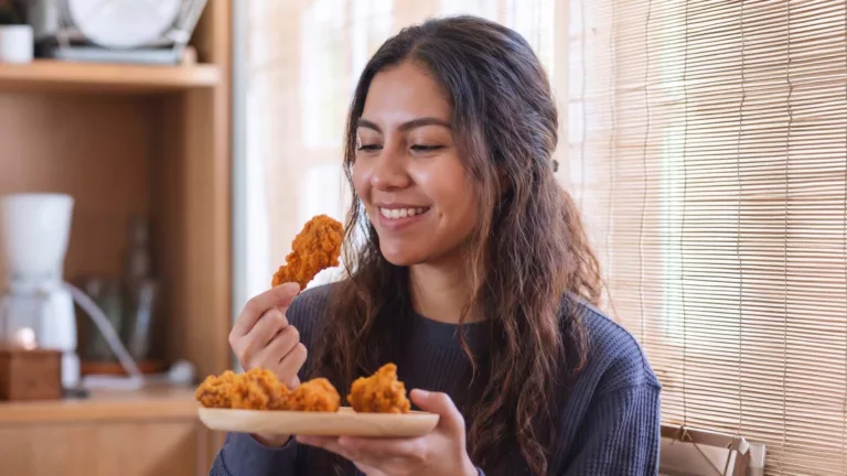 Consumidora saboreando frango empanado em casa, exemplo de qualidade preservada até o consumo